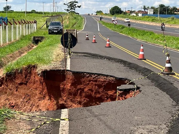 Cratera aberta pela chuva interdita parte da marginal de rodovia em Guapiaçu